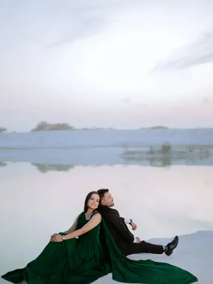 A peaceful, contemplative moment as the couple looks out over the landscape. The soft evening light creates a serene and romantic mood for this pre-wedding photo.