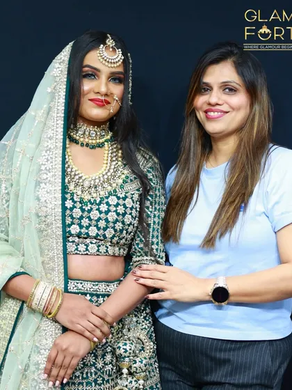 Here I am with a student's model, showcasing a stunning Valima look. The makeup is soft and glamorous, with a focus on shimmering green eyeshadow to match the outfit.