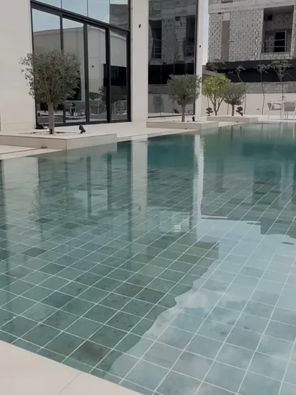 The reflection of the sky and our planted trees in the still pool water adds a sense of tranquility to this modern outdoor space.