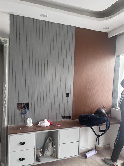 Another behind-the-scenes shot from a site in progress. Here, you can see the TV wall unit being constructed, with the grey and copper-colored panels being installed.