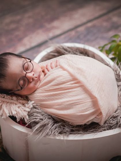 A peaceful scholar at rest. This setup combines a classic basket pose with the whimsical touch of tiny glasses for a memorable portrait.