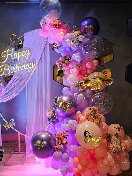 Another beautiful take on the butterfly theme, this time with a more dramatic color palette. The deep purples and pinks, combined with gold butterfly accents and a neon sign, create a sophisticated and magical look.