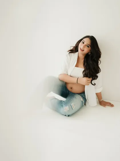 A happy, relaxed portrait. This mom to be chose a classic white shirt and ripped jeans for her casual maternity session, and she looks absolutely glowing.