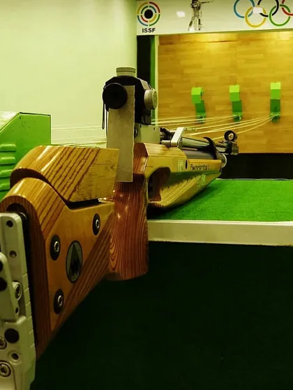 A close-up of a Feinwerkbau air rifle resting on the lane. We believe in training with world-class equipment to give our shooters the best possible advantage.