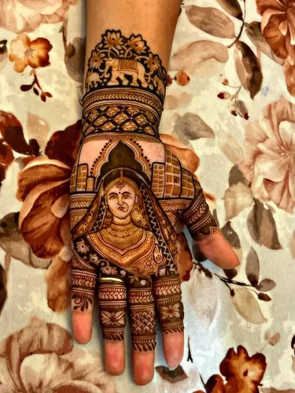 A close-up of a bridal portrait on the palm. Creating realistic faces with henna requires a lot of skill and attention to detail, making the design truly one of a kind.