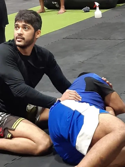 Close-up of a student coaching another during a grappling session. This peer-to-peer teaching is a core part of our community and helps everyone solidify their knowledge.