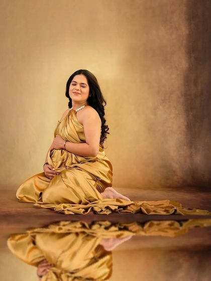 A creative portrait using a reflection to enhance the beauty of the golden satin drape.