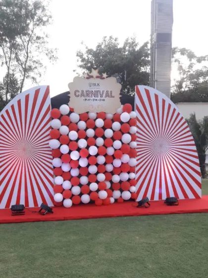 Our carnival theme photo booths are perfect for family days and corporate events. This setup uses a classic red and white color scheme with pinwheel patterns and a balloon wall for fun, memorable pictures.
