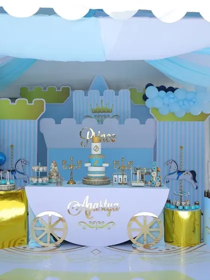 A full view of a Prince-themed 9th birthday party. The setup includes a tented ceiling, a castle backdrop, and gold accents, showing how we can adapt a theme for older children while keeping it fun and regal.