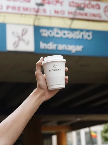 Adventures are better with a Paper & Pie coffee in hand, pictured here in front of the iconic Indiranagar metro station.