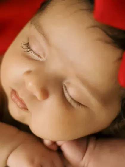 A macro shot focusing on the baby's delicate eyelashes and sweet sleeping face. These are the tiny details you'll never want to forget.