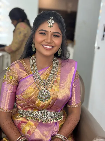 My beautiful bride Gopika chose this grand silver-toned set with green and red stones for her reception in Karur. It's a statement piece that commands attention.
