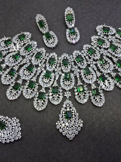 A statement American Diamond and emerald necklace set in a peacock feather design, perfect for a reception.