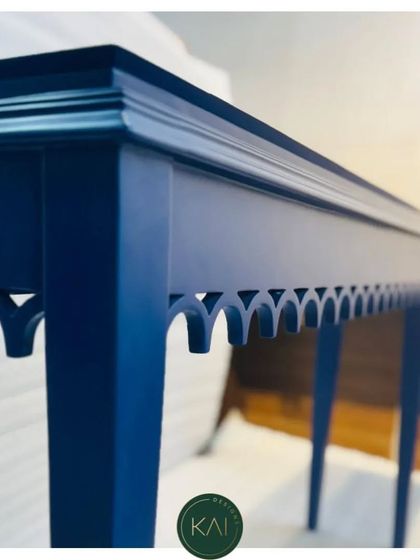 A detail shot of the blue console table, focusing on the crisp lines of the tabletop and the delicate cut-out pattern.
