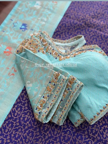 A light blue blouse with a simple embroidered cuff.