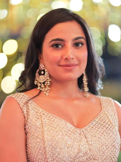 A close-up portrait of Shivani Rai, her large earrings adding to the glamorous look.