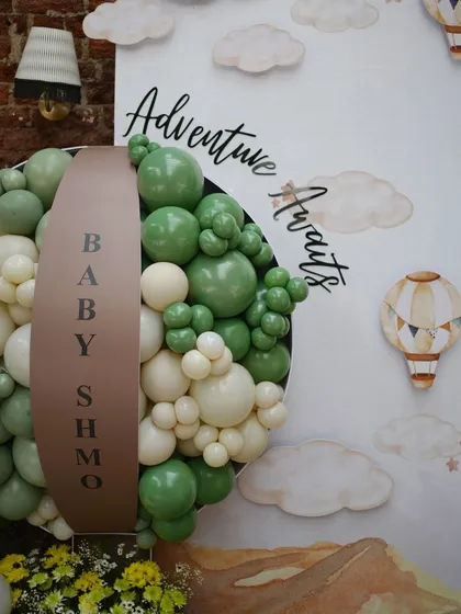 Another angle of the bespoke balloon art, highlighting the 'Adventure Awaits' script against the custom-painted backdrop.