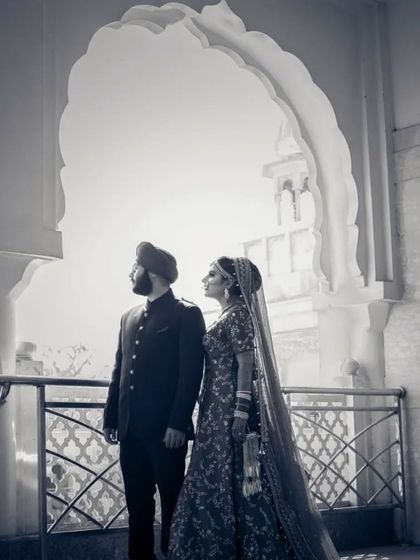 A timeless black and white portrait of a Sikh couple, framed by a beautiful archway, creating a classic and elegant composition.