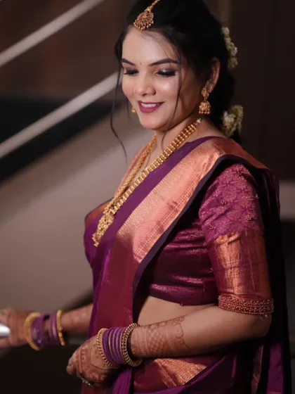 This bride chose a rich magenta saree for her engagement. The makeup features a soft smokey eye and a matching lip color.