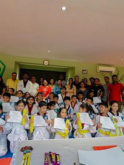 A large group photo with students and their families after a successful belt promotion test. The support from parents is invaluable.