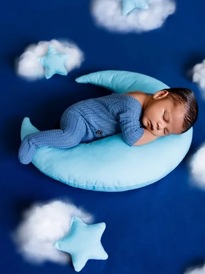 A tiny dreamer sleeping amongst the clouds and stars. This setup creates a serene, celestial portrait for your newborn boy.