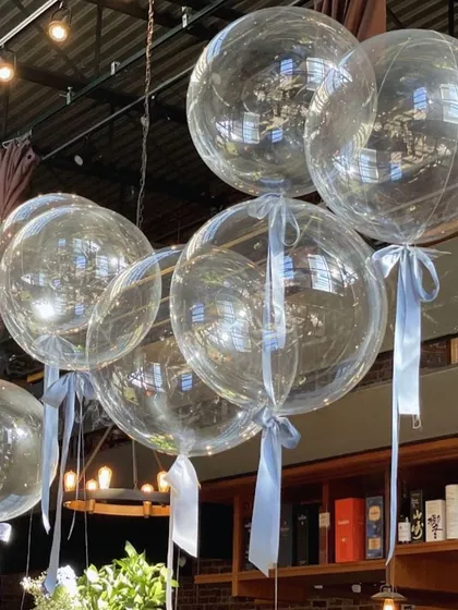 Clear helium bobo balloons with simple blue ribbons. Sometimes less is more, and these add a touch of elegance and fun to any space.