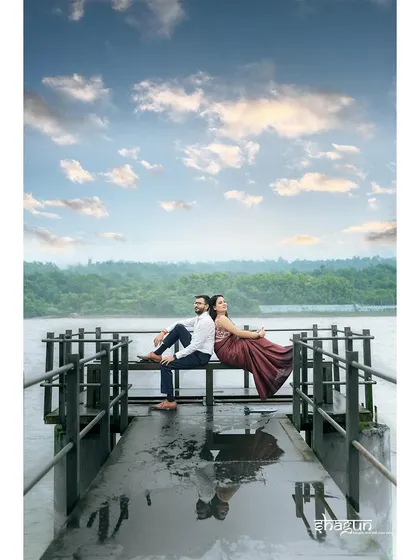 Back to back on a wet jetty, with their reflections in the water below. This is a beautifully composed, symmetrical shot that captures a moment of quiet connection.