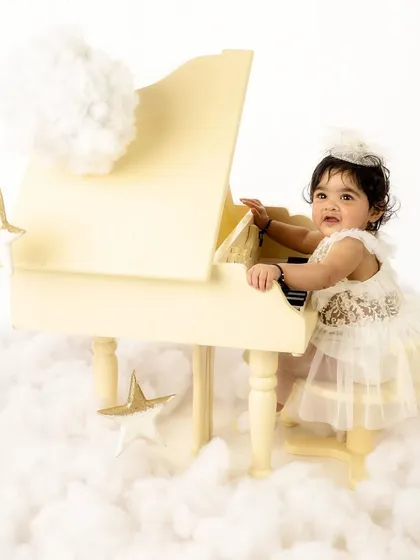 Playing the piano in the clouds. This whimsical setup is perfect for capturing the dreamy innocence of childhood.