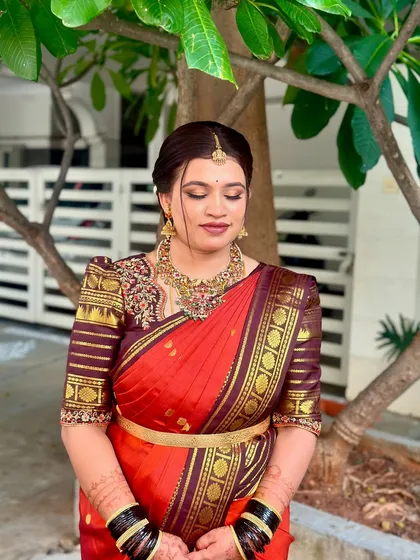 A serene and elegant portrait of this bride in a rich red and maroon silk saree. The makeup is classic and understated, letting her natural beauty shine.