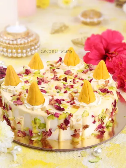 This is my Kesar Peda cake, another one of my Indian fusion creations. The cake is flavoured with saffron and cardamom and decorated with crumbled pedas, pistachios, and rose petals for a truly festive treat.