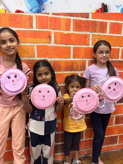 Our art and craft workshops are a place for little artists to shine. Here, a group of proud creators show off their finished paper plate animals, a fun activity that helps develop fine motor skills and sparks imagination.