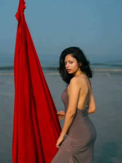 An over-the-shoulder glance that is both alluring and elegant. The backless dress is highlighted by this pose.