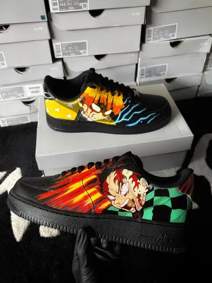 A powerful design on black Nike Air Force 1s showcasing Tanjiro and Zenitsu from Demon Slayer, with their signature elemental attacks flowing across the shoes.
