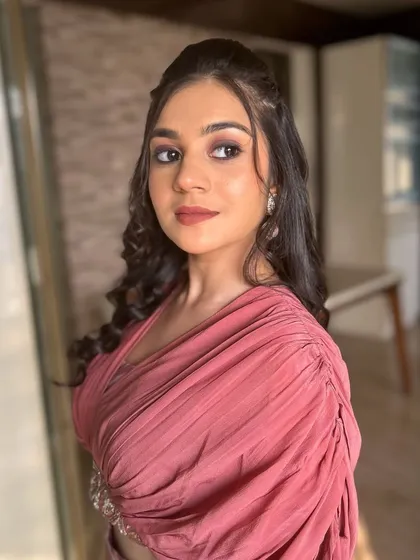 A modern and chic look. The client's draped outfit is paired with a soft, monochromatic makeup look in dusty rose tones.