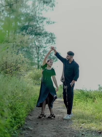 A couple shares a dance on a rustic path, a spontaneous and happy moment from their outdoor pre-wedding session.