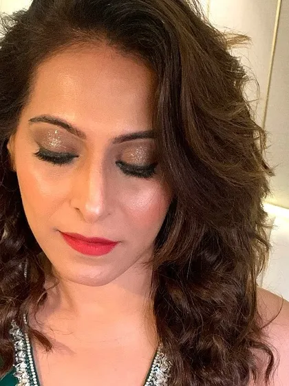 A close up of a party makeup look. I used a beautiful champagne glitter on the eyelids to make them pop, paired with a classic red lip.
