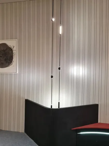 A corner of our booth showcasing minimalist pendant lights against a textured, pinstriped wall. This vignette was designed to inspire architects and designers with creative ideas for their own projects.