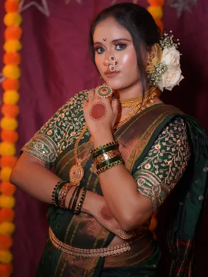 A full-length shot capturing the grace of the Nauvari saree and the complementary bridal makeup. The entire look is tied together with traditional green bangles and gold jewelry.