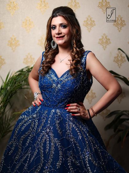 A model poses confidently in a heavily embellished royal blue evening gown, showcasing our work with modern Indian occasion wear.