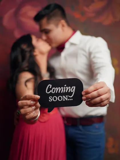 A fun and sweet announcement from an expecting couple. This playful shot, with a "Coming Soon" sign, perfectly captures the excitement and shared joy of their journey to parenthood.