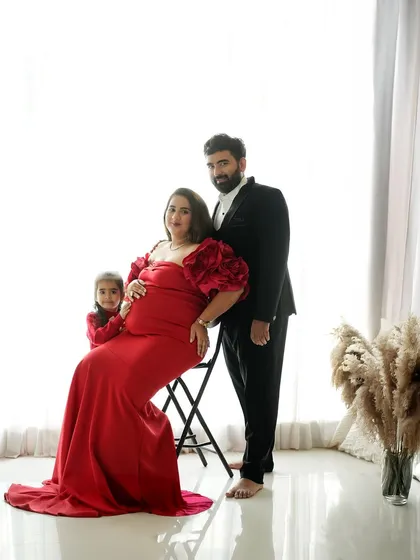 A formal studio portrait celebrating the next chapter. This maternity session captures the elegance and excitement of a growing family, with coordinated outfits creating a classic, polished look.