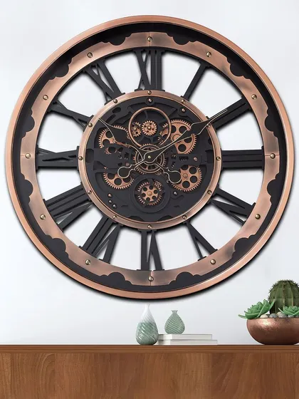 This industrial-style wall clock features a large, open frame in a copper finish with black Roman numerals. The intricate moving gears at the center create a stunning visual focal point.