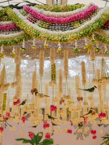 Another perspective of the hanging floral arrangements in the mandap. The combination of different flowers and the handcrafted parrots created a design that was both traditional and full of life.
