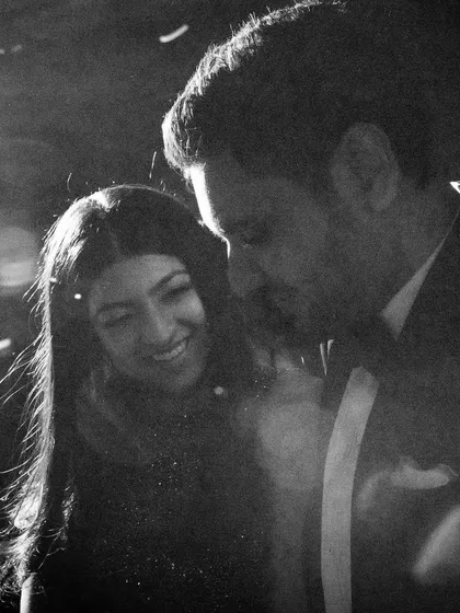 A grainy, candid shot of Tanya and Shivam dancing at their party. The imperfect technicals are overshadowed by the perfect emotion, their smiles radiating pure happiness in a stolen moment.