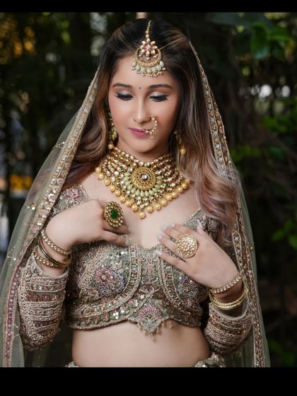 A close-up of the heavy jewellery set paired with this pastel lehenga, featuring a large choker, maang tikka, and nath.