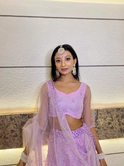 A beautiful bridesmaid in a lavender lehenga. The makeup is soft and elegant, with a focus on lilac eyeshadow to match her outfit.