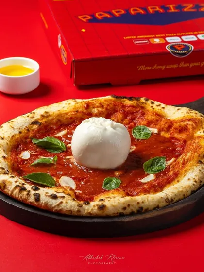 A Neapolitan-style Burrata pizza, photographed for Paparizza's online ordering platform. The lighting is designed to emphasize the fresh, creamy burrata and the perfectly baked crust, making it irresistible for delivery app users.