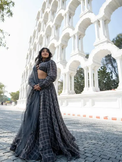 This grey plaid lehenga is perfect for those who want a fashion-forward, gothic-inspired Indian look. It's playful, unique, and available to rent.