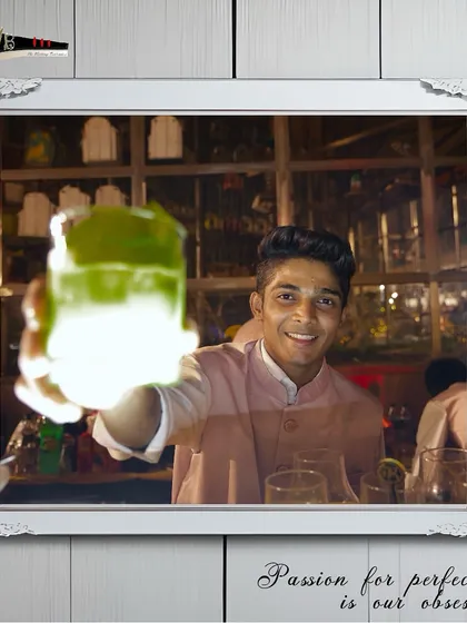 A bartender presents a glowing green mocktail, a visually striking drink that tastes as good as it looks.