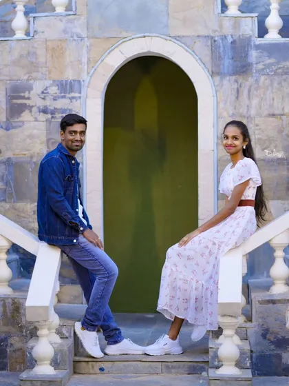 A casual and symmetric pose on a stone balustrade. The couple's relaxed outfits are perfect for this simple, elegant setting.